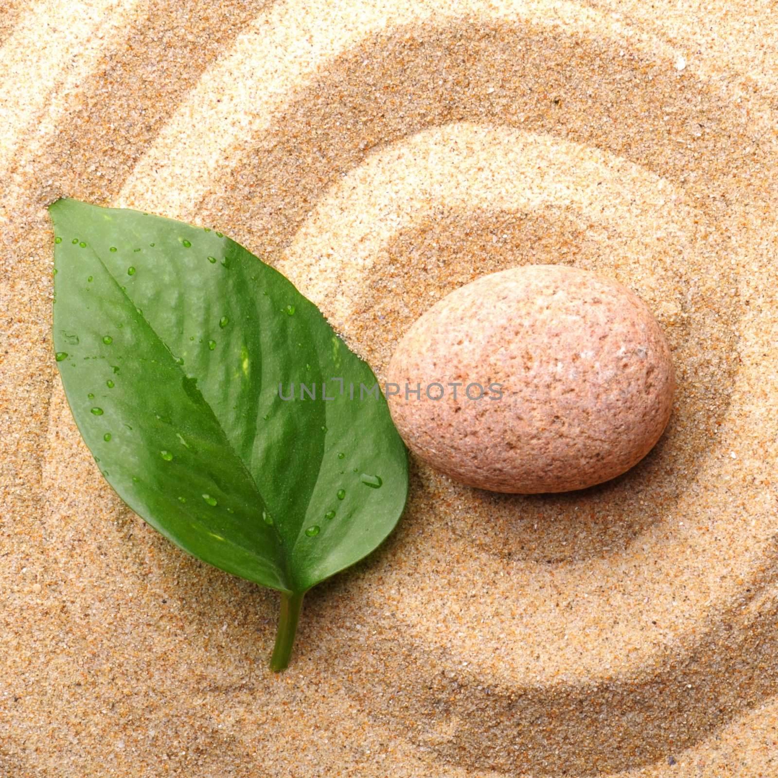 zen garden with stone or pebble on sand with leaf