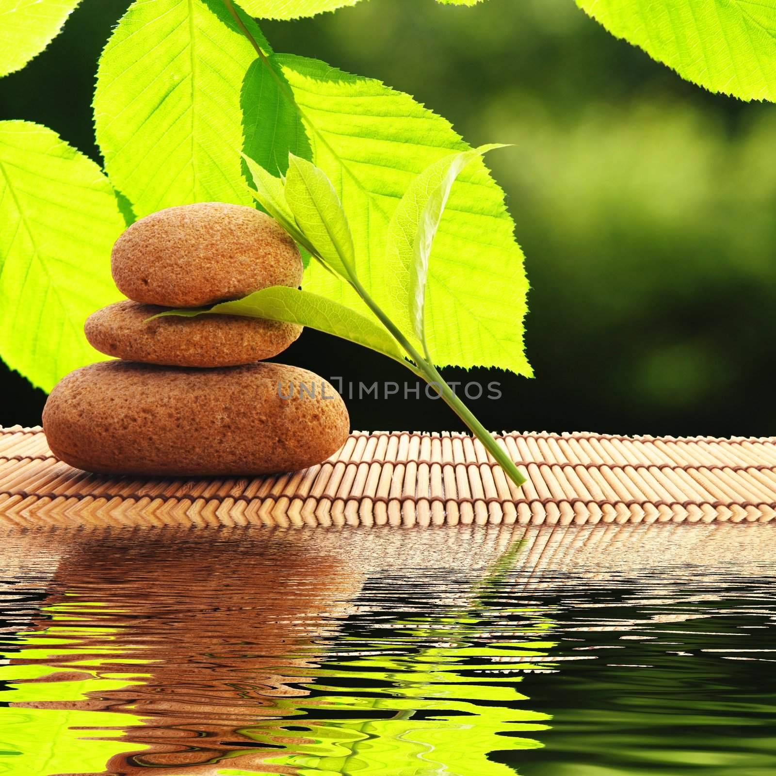 zen stones and water reflection showing spa concept