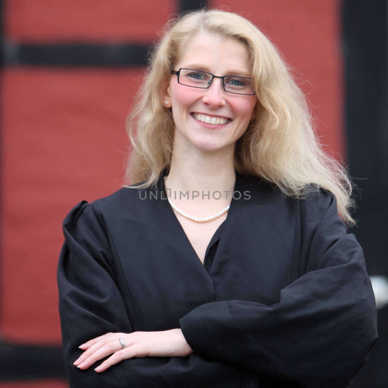 Law student or lawyer smiling with arms folded in a robe
