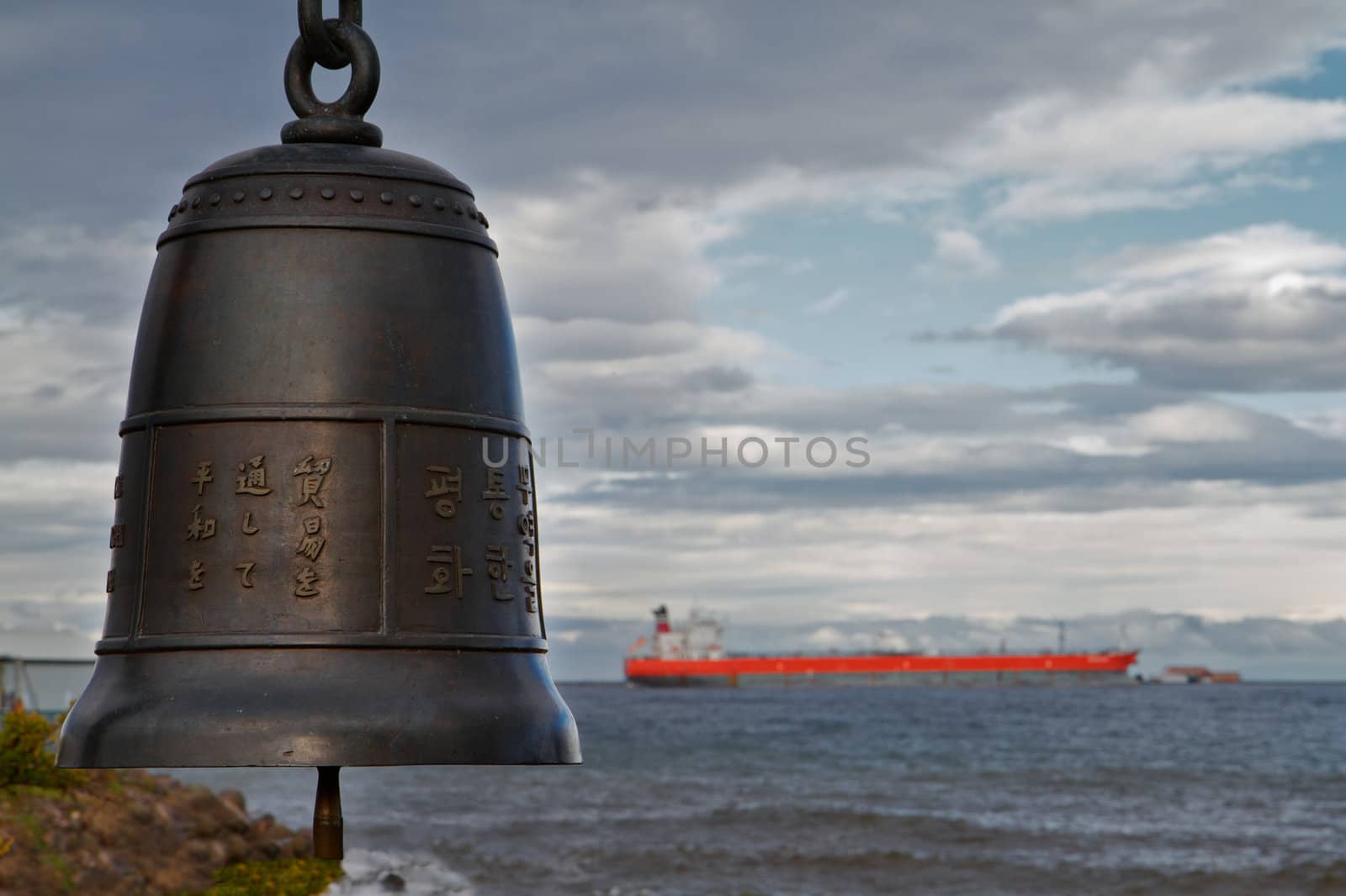 Bronze Chinese Bell with soft focus frieghter in background