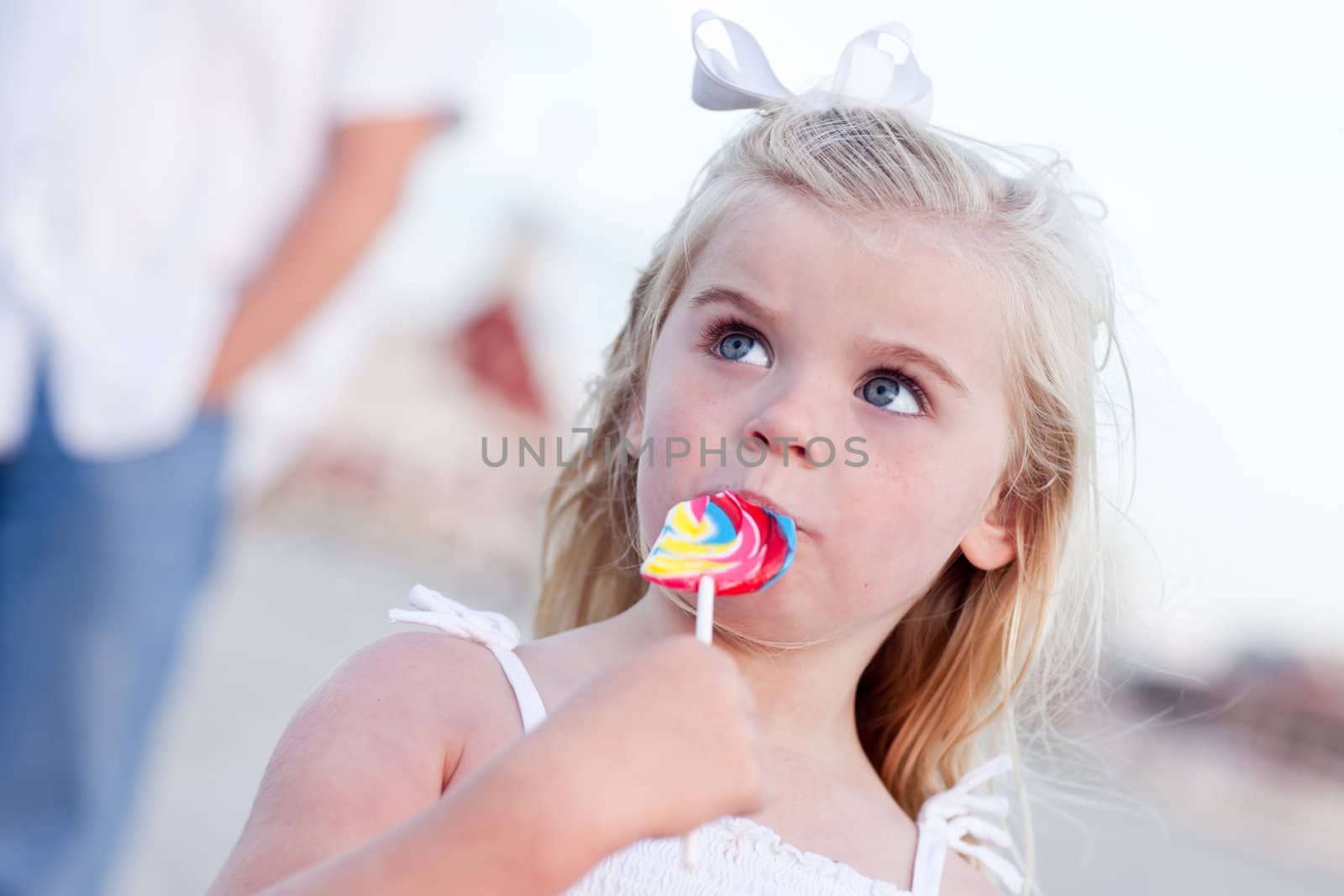 Adorable Little Girl Enjoying Her Lollipop Outside at the Beach.