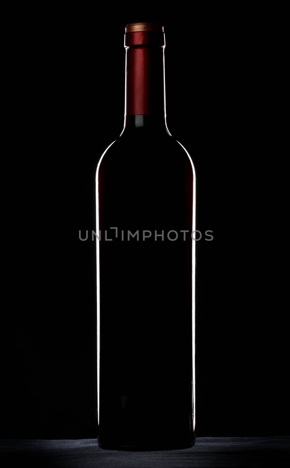 Red wine bottle silhouette over black background