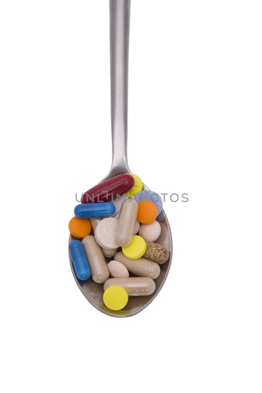Teaspoon with pills and capsules isolated on white background