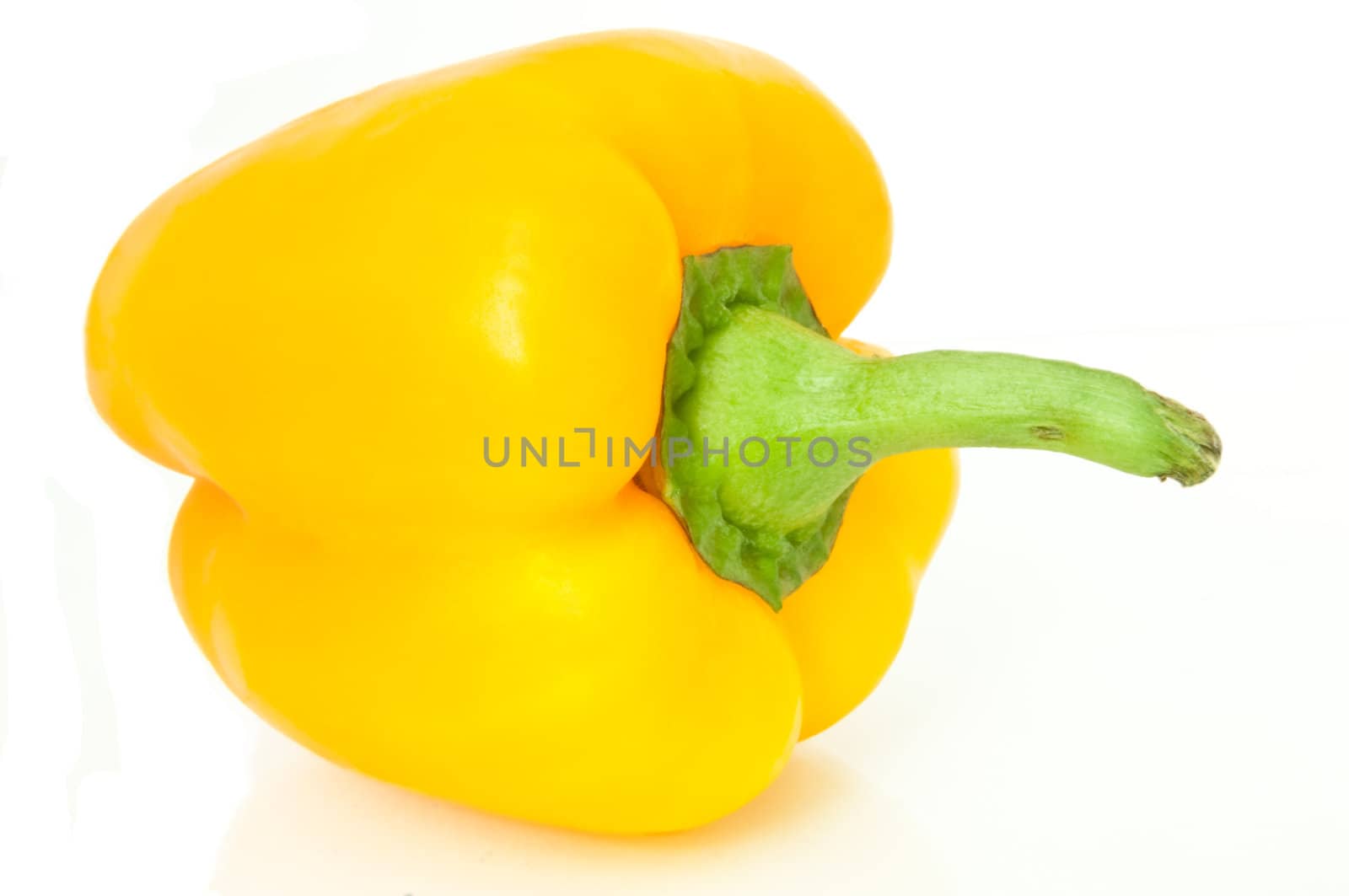 Close up, low level angle capturing a single yellow bell pepper isolated over white.