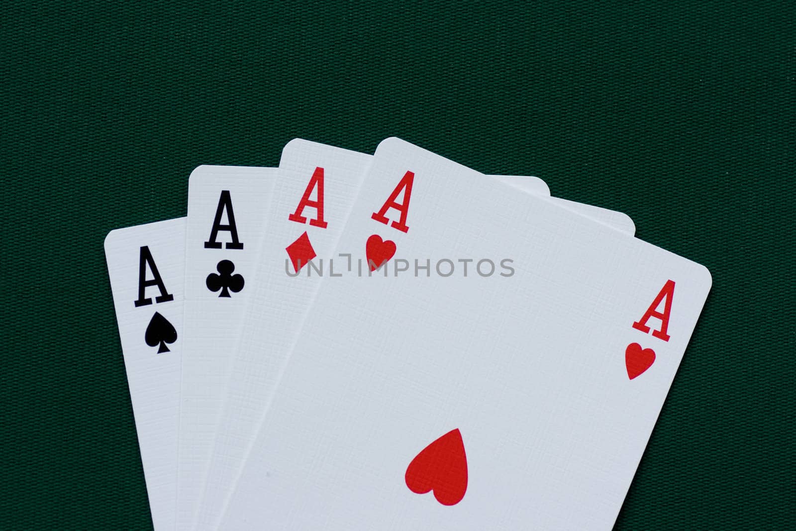 Playing cards - four aces on green background.