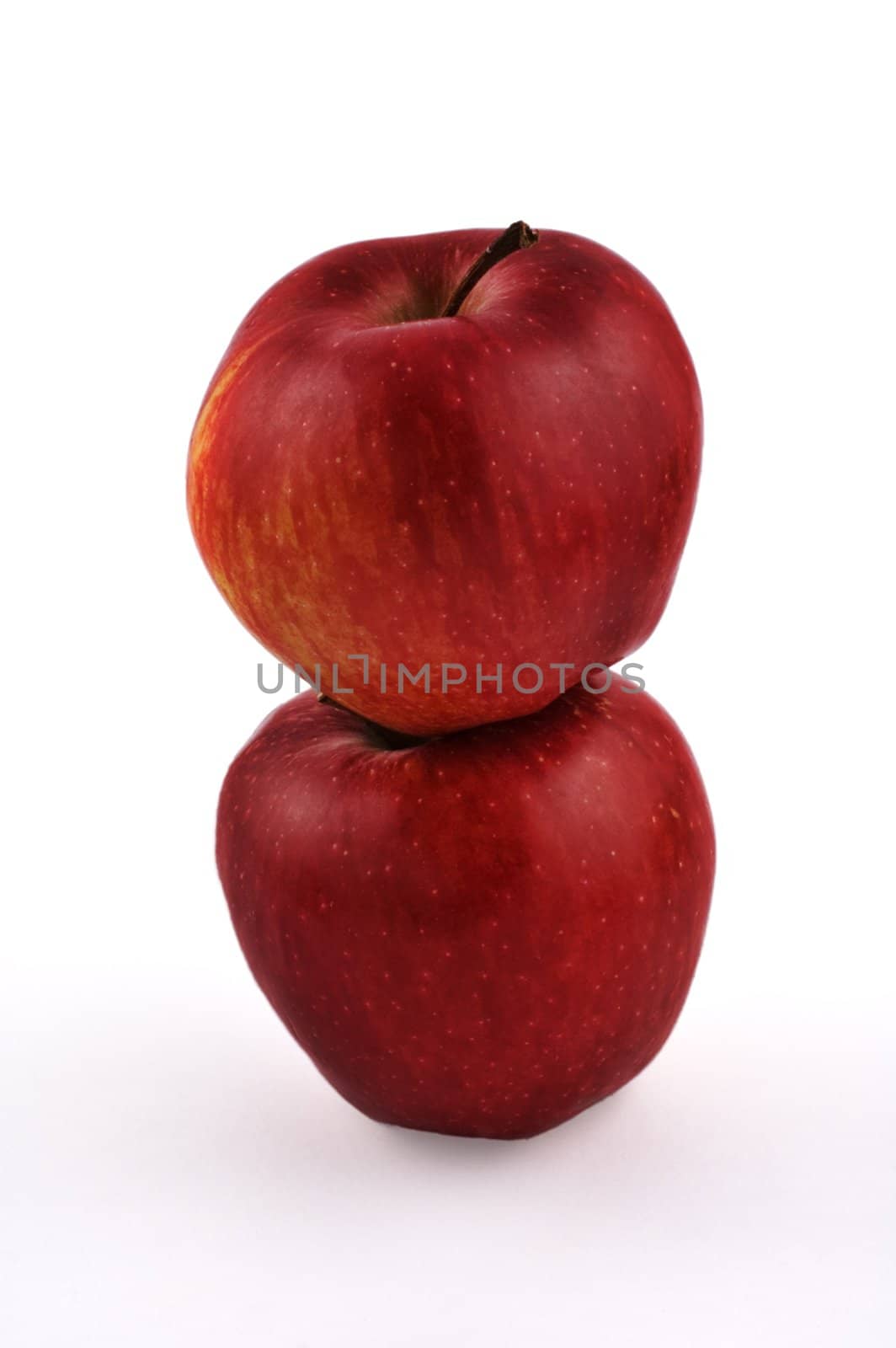 Two stacked red apples on white background with slight shadow