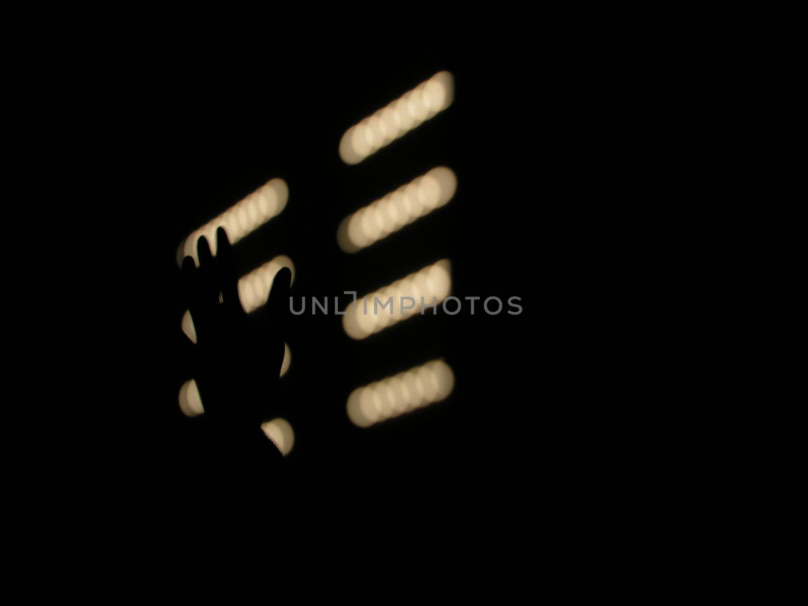 Silhouette of hand and shutter on black background         