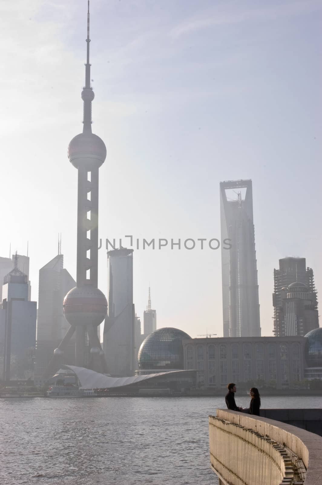 Couple talks on Shanghai's Bund at sunrise