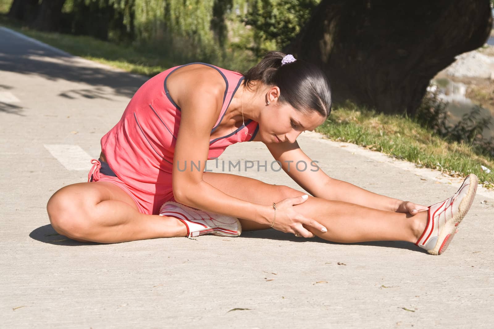 Woman doing stretching movements outdoors in a park.Shot with Canon 70-200mm f/2.8L IS USM