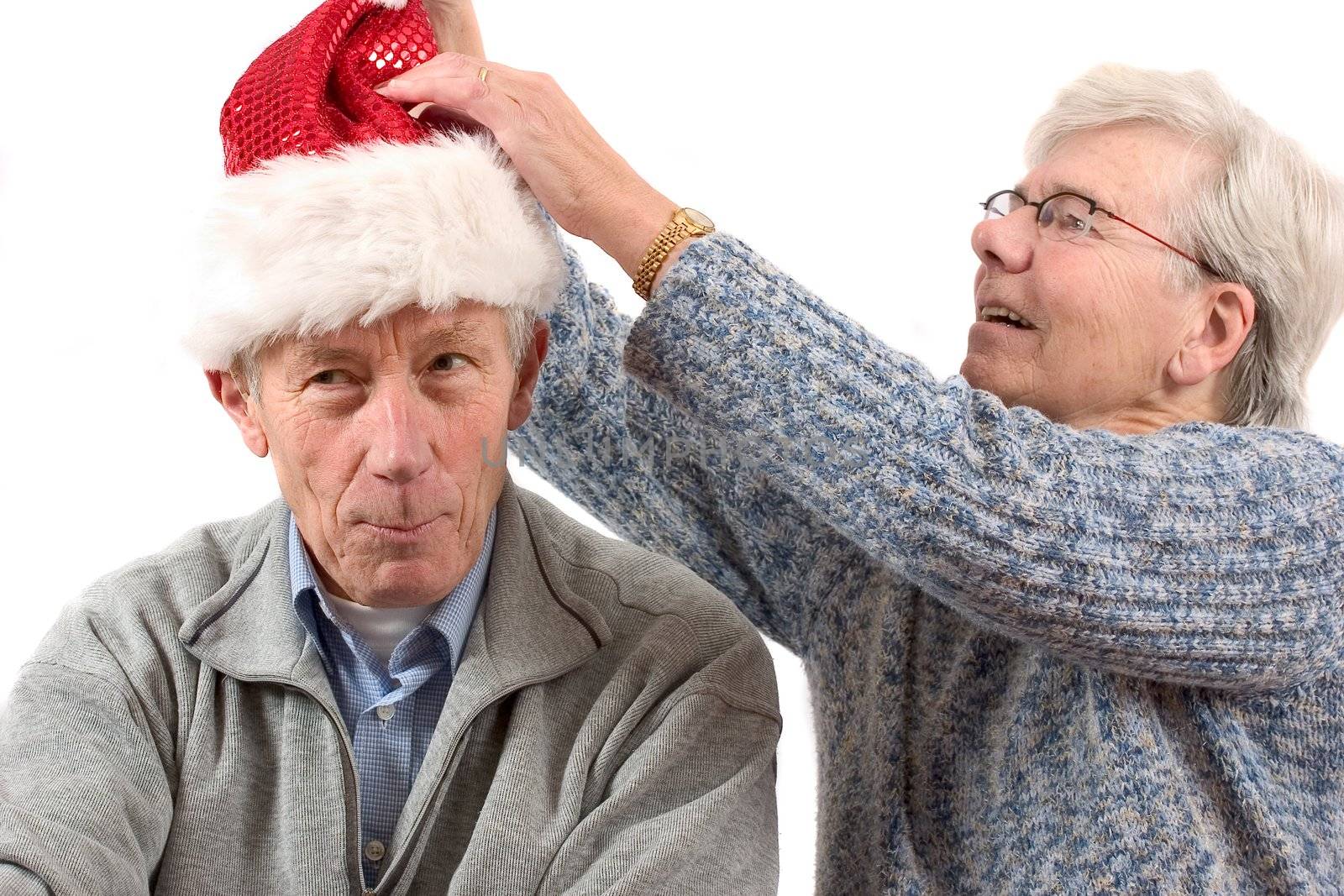 Woman putting a santa hat on her husbands head