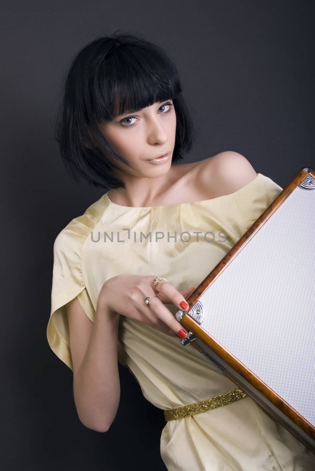 A beautiful brunette posing with suitcase 