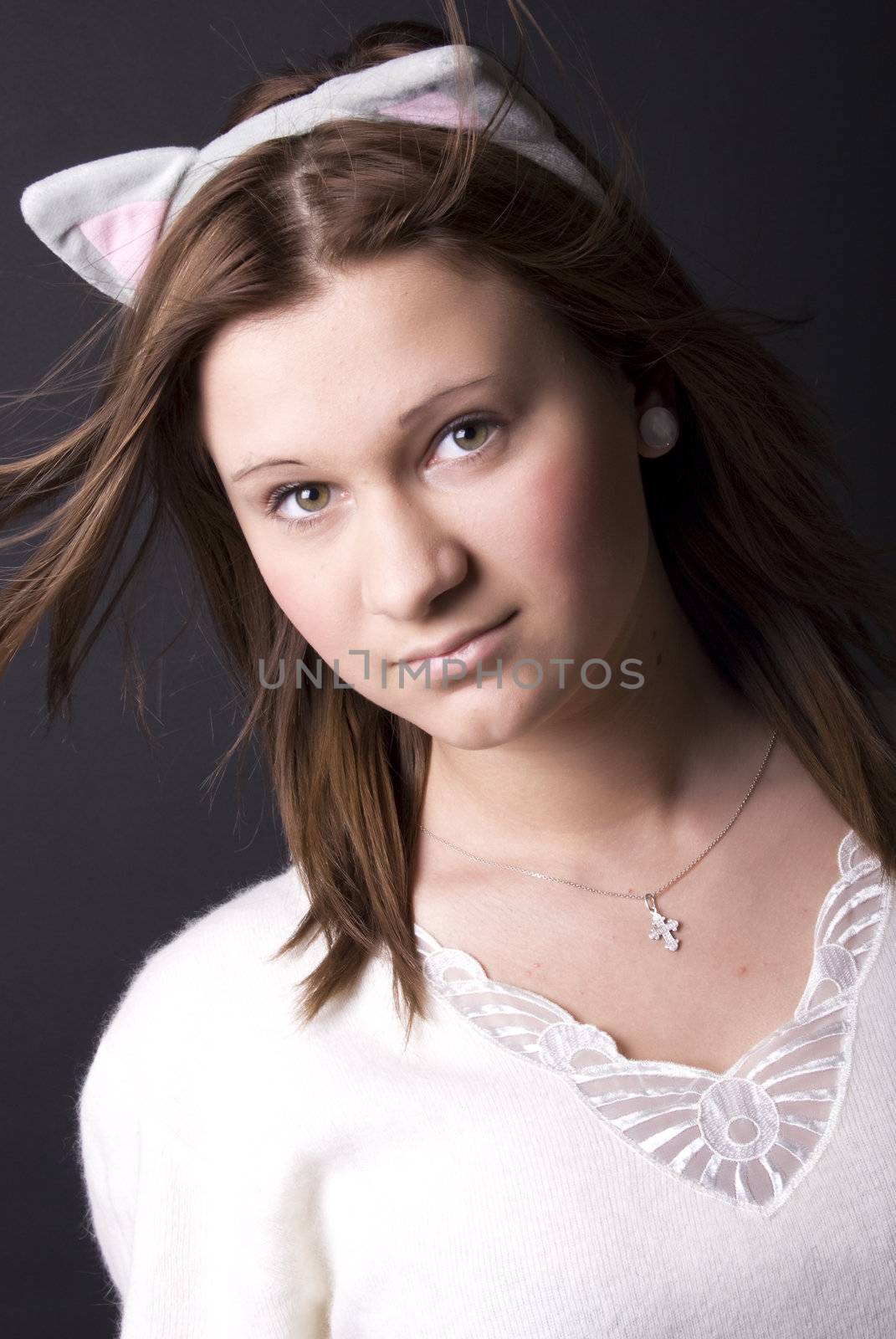 Portrait of a young beautiful girl with cats ears on the head