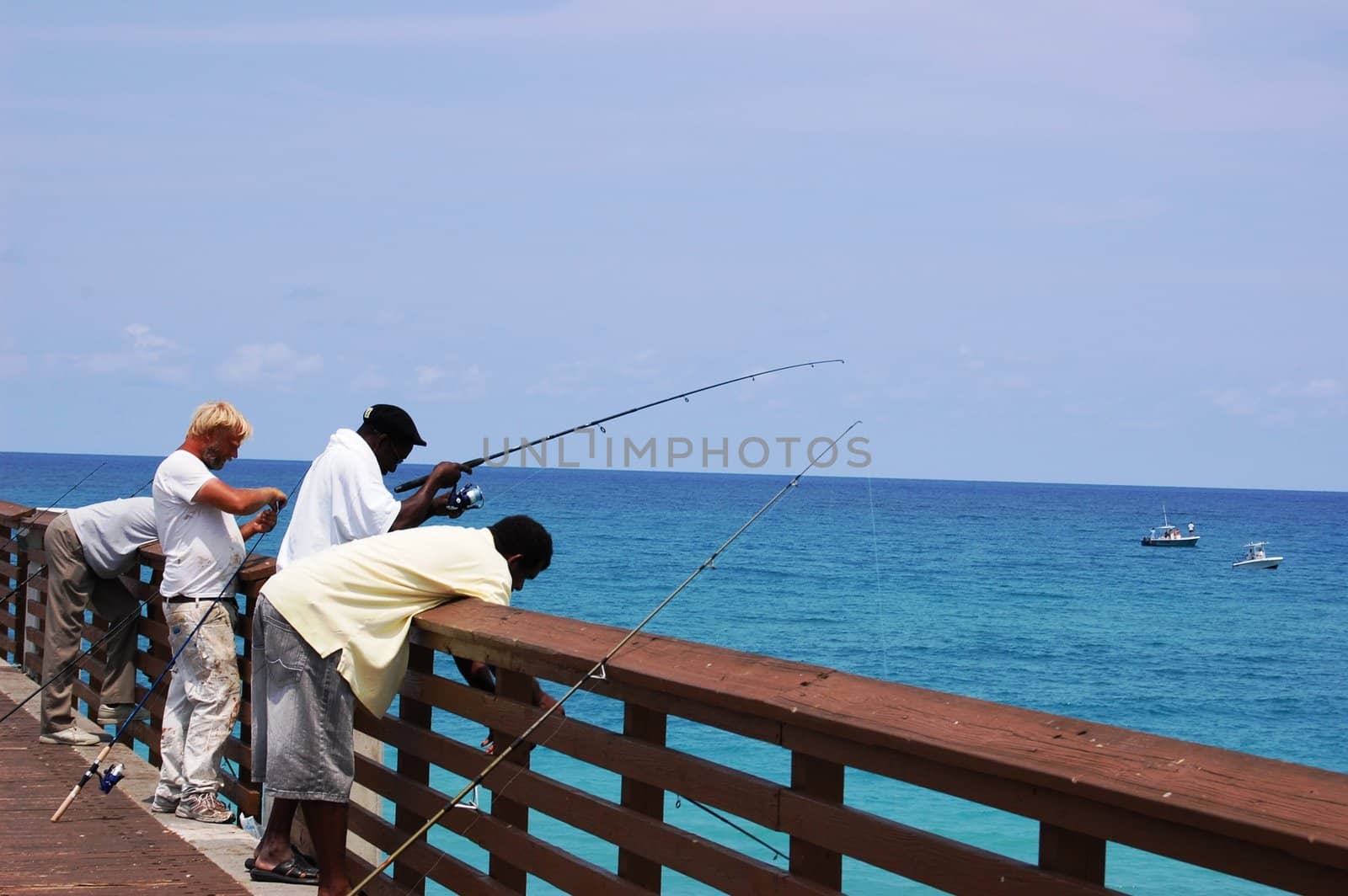 Men fishing on pier by RefocusPhoto