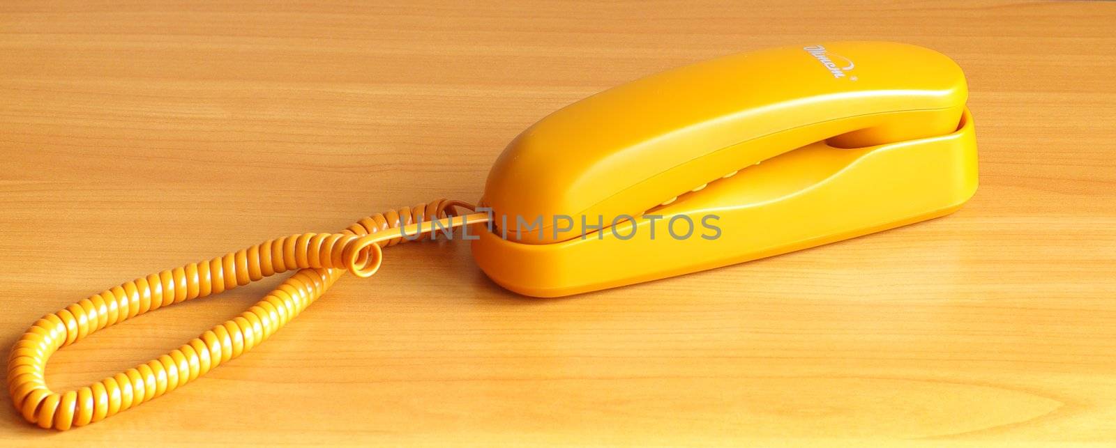 yellow color stationary telephone on the table  