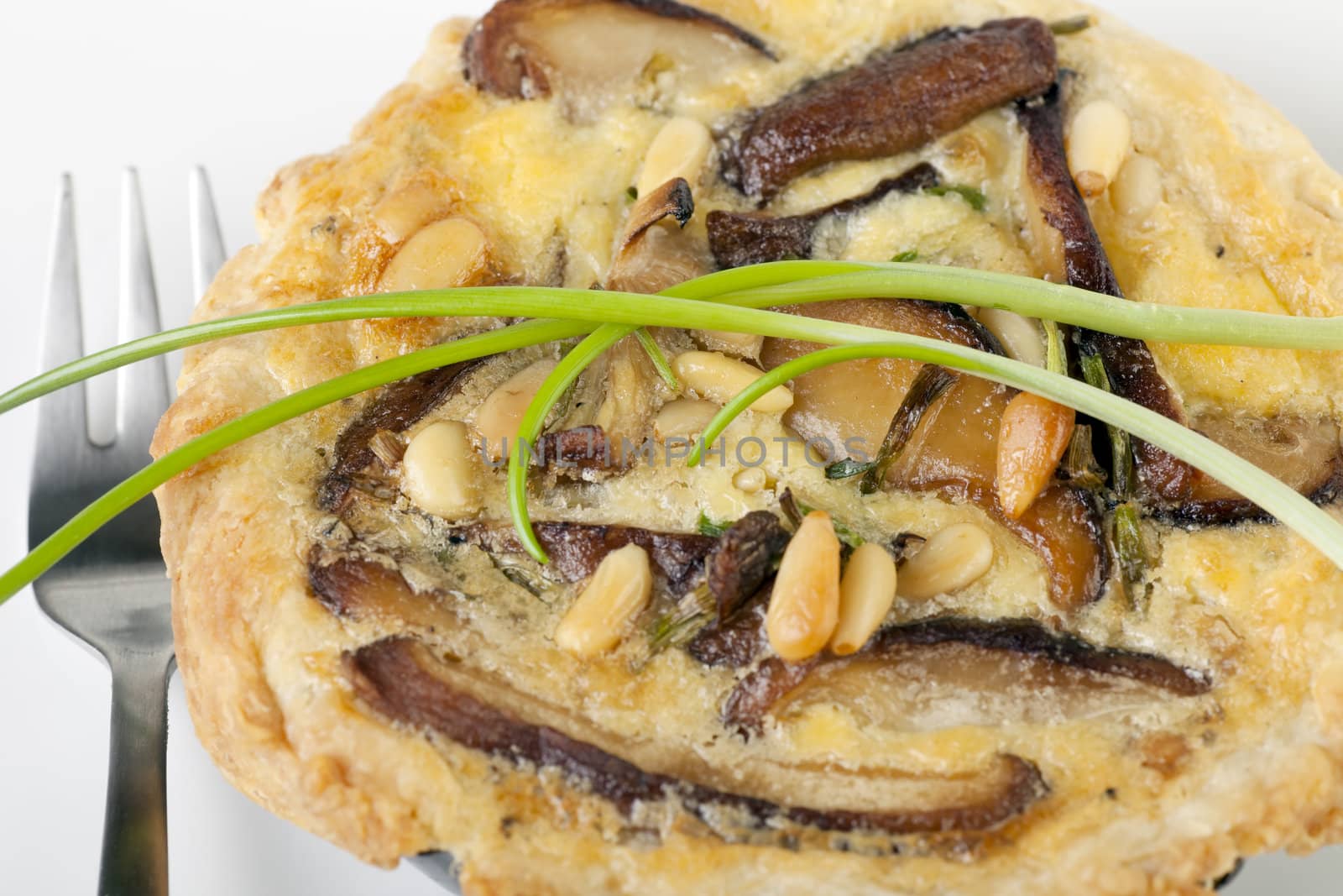 Small Quiche appetizer with shitake mushrooms and pine nuts.