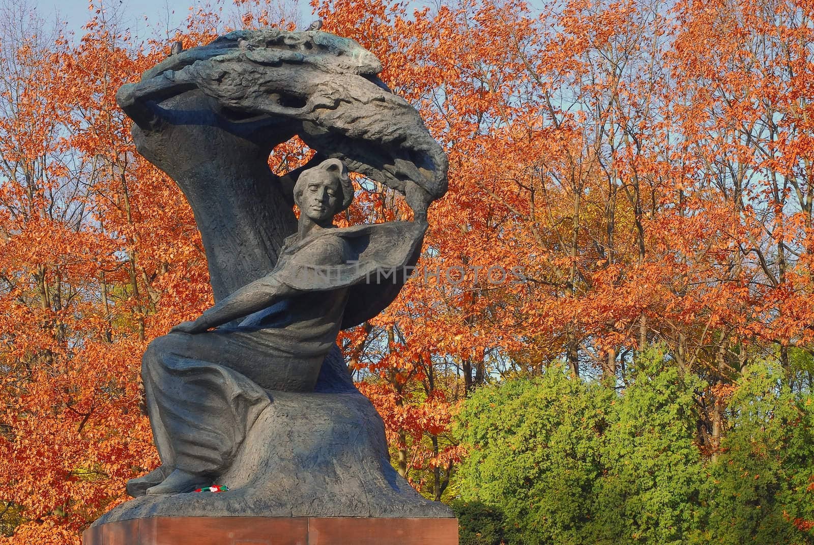 Chopin bronze old monument in Lazienki park in Warsaw. Autumn time.