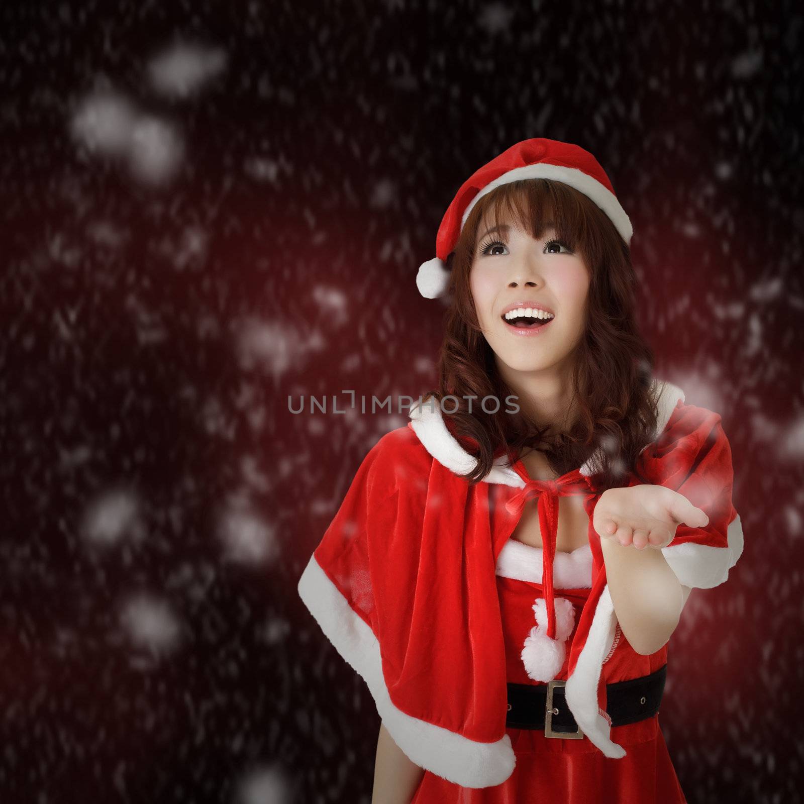 Christmas woman smiling and looking with snowflakes over red background.