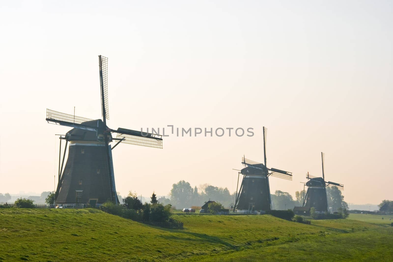 Three watermills after sunrise view from polder