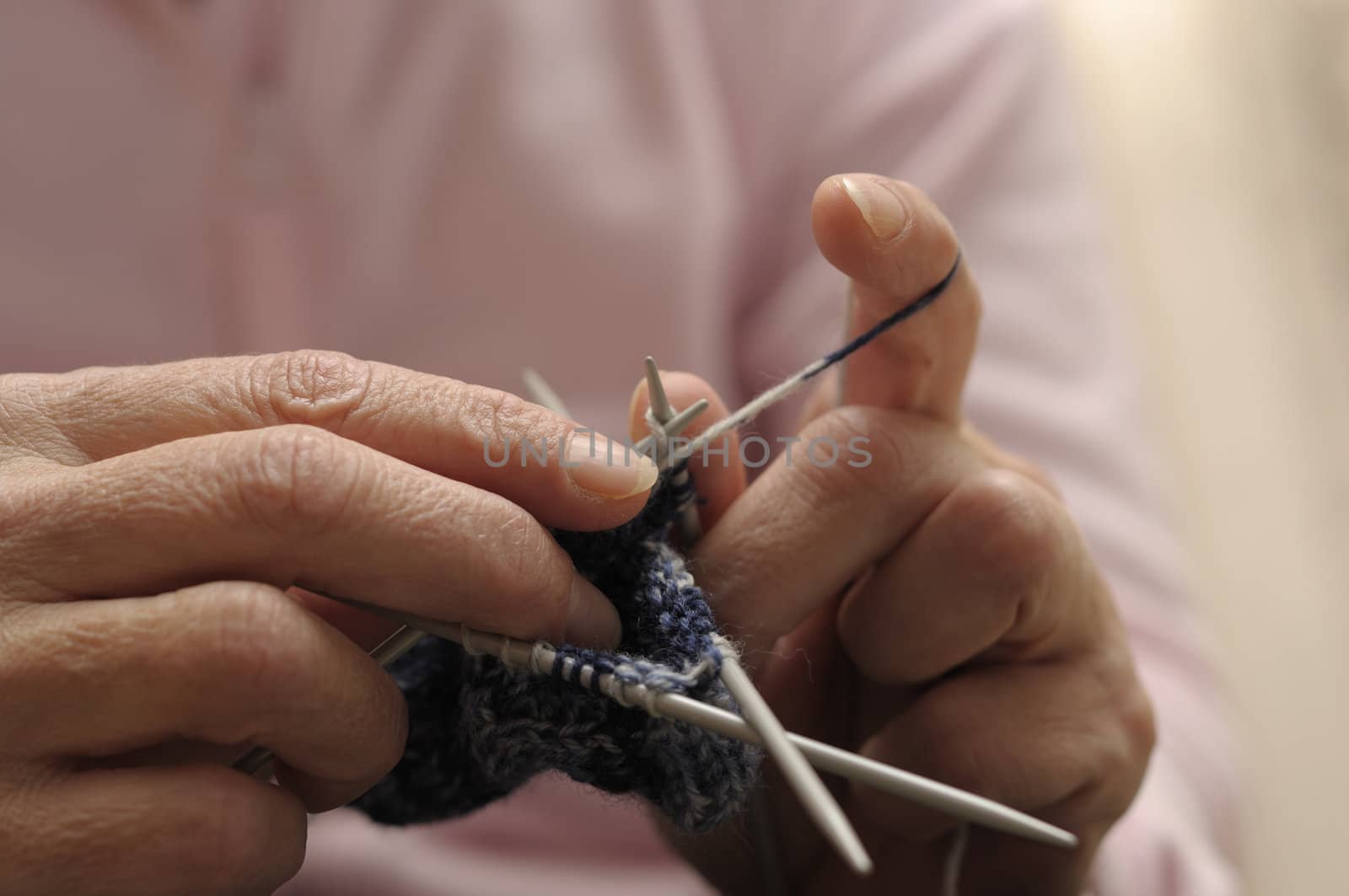 Female Hand knitting with blue wool