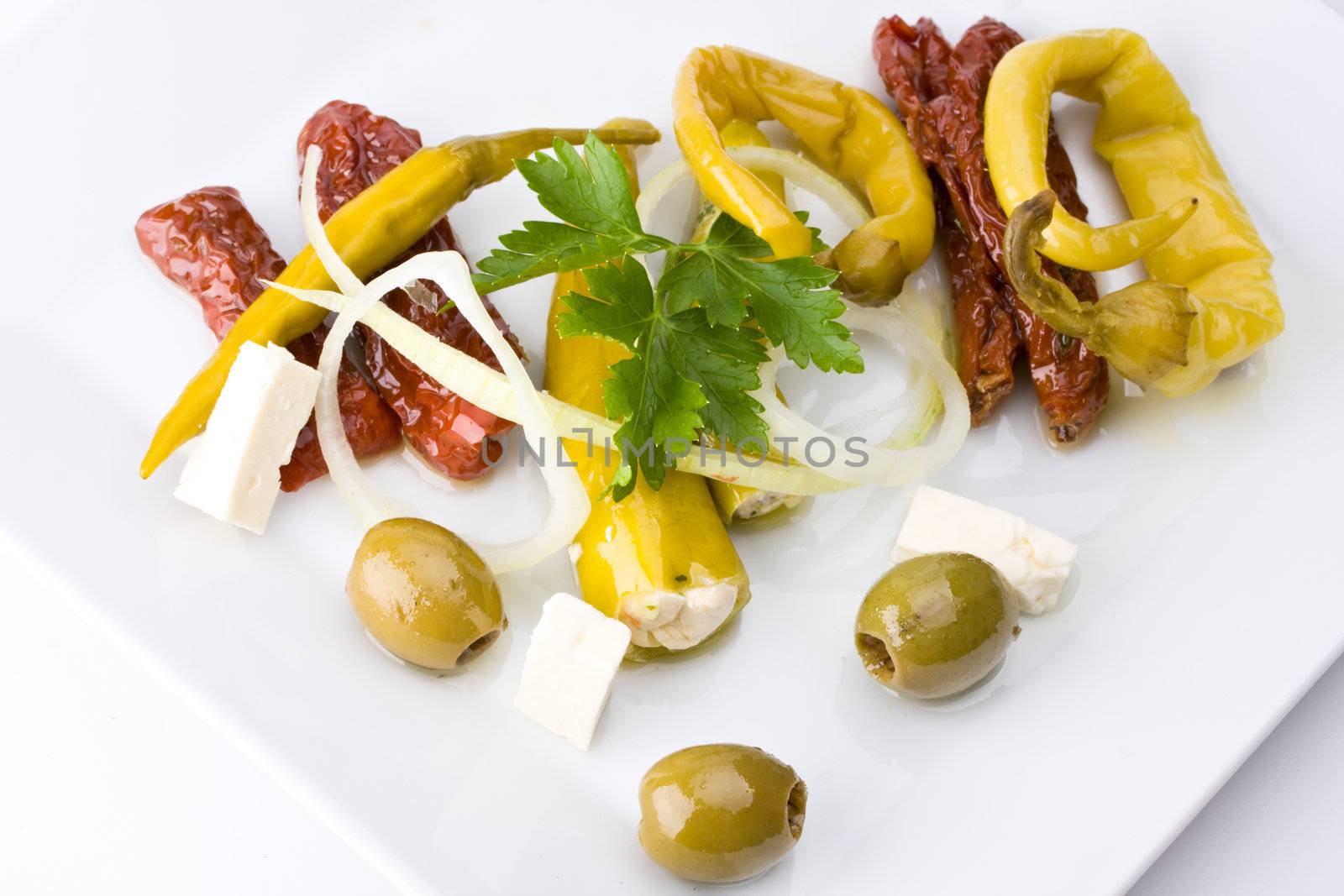 white plate with antipasti - olives, tomatos and peperoni by bernjuer