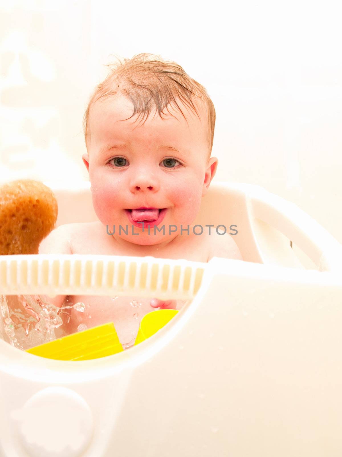Happy baby boy  sitting in his bath