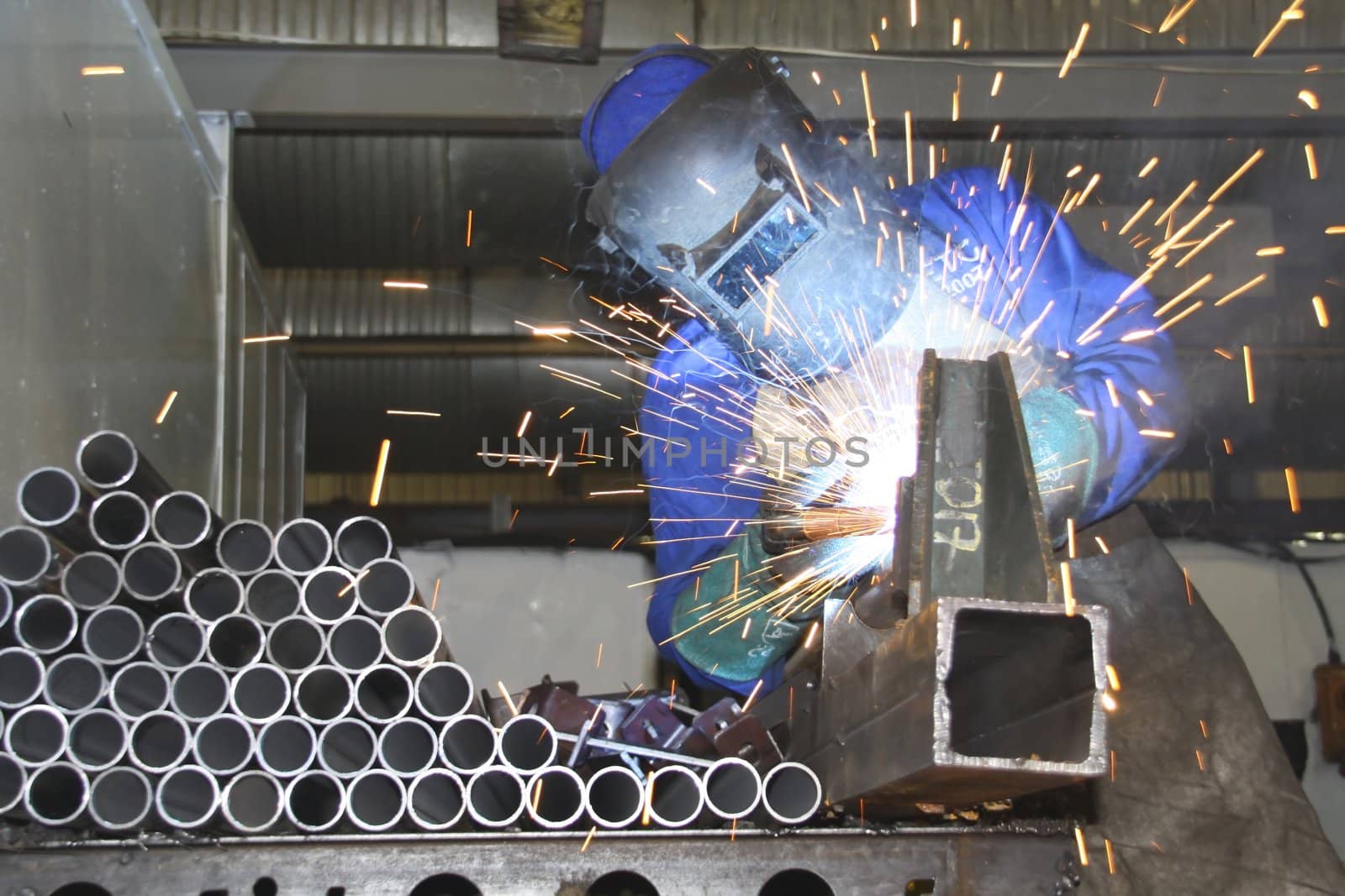 Artisan welding tubes and pipes on a production line