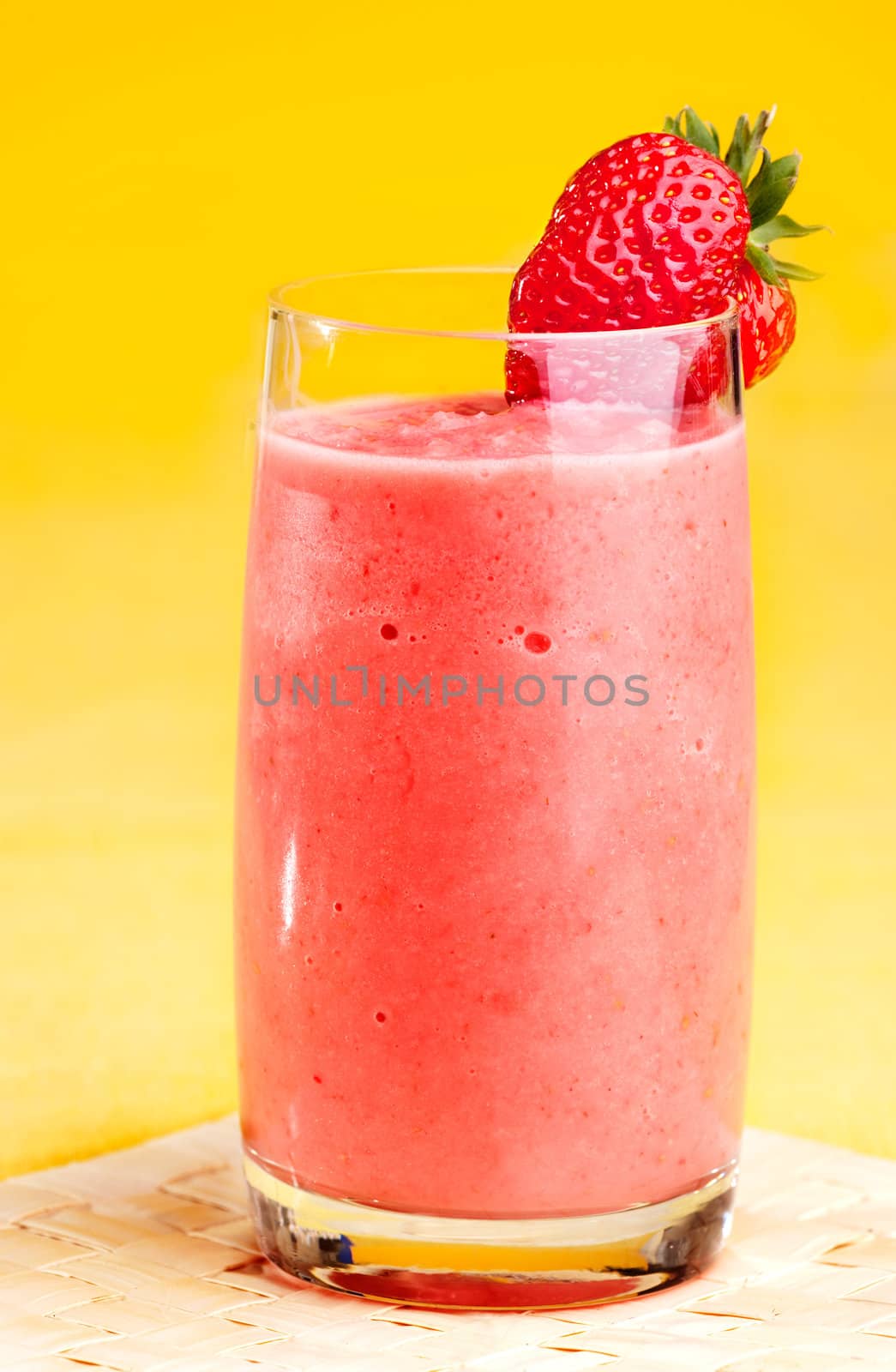 A fresh strawberry smoothie isolated over yellow