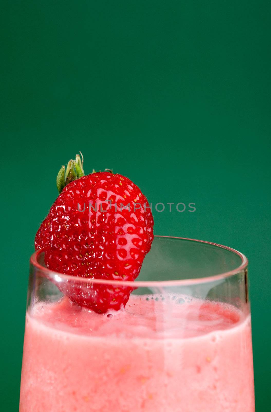 A fresh summer strawberry drink isolated on green