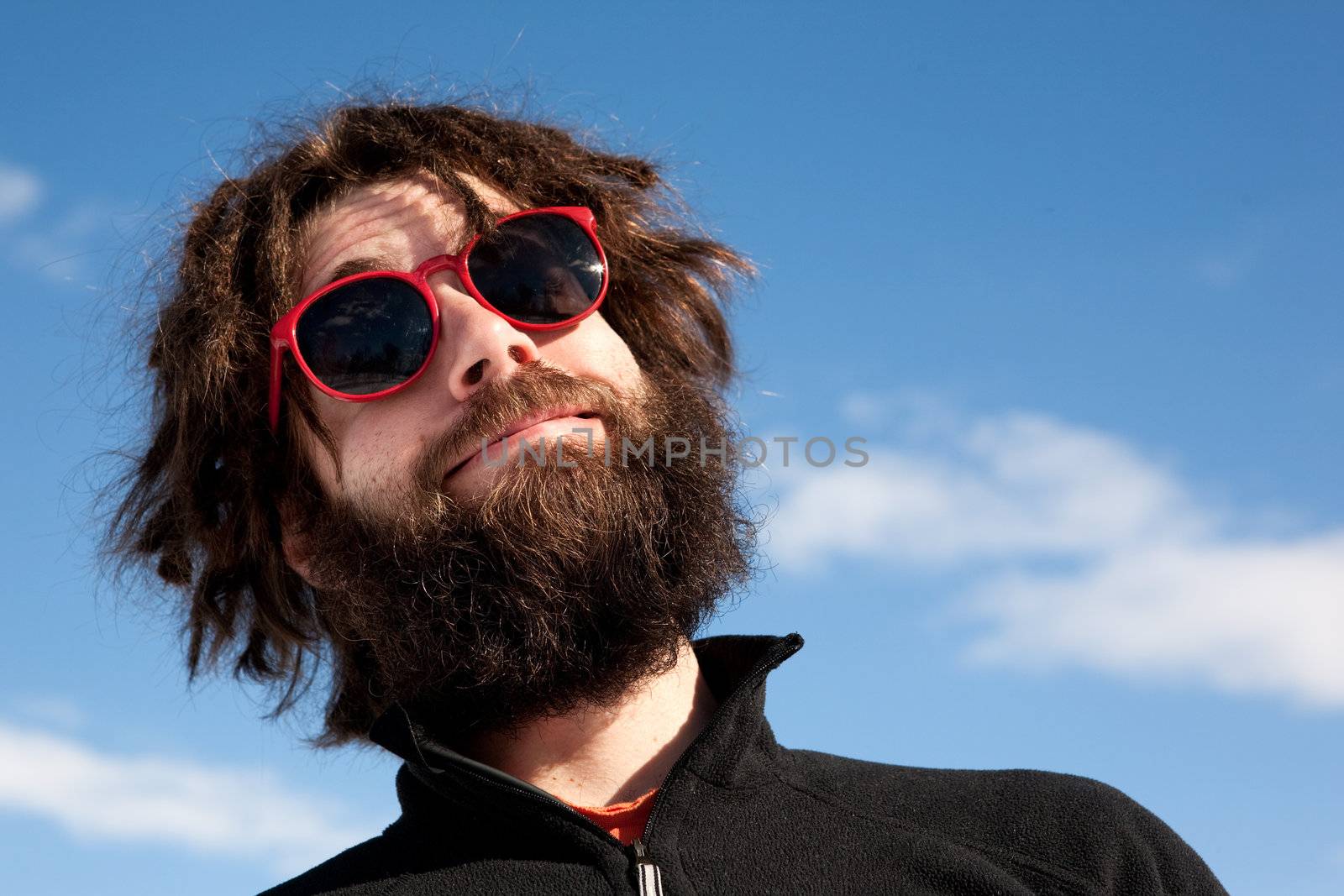 A funny portrait of a male with a full beard and sunglasses