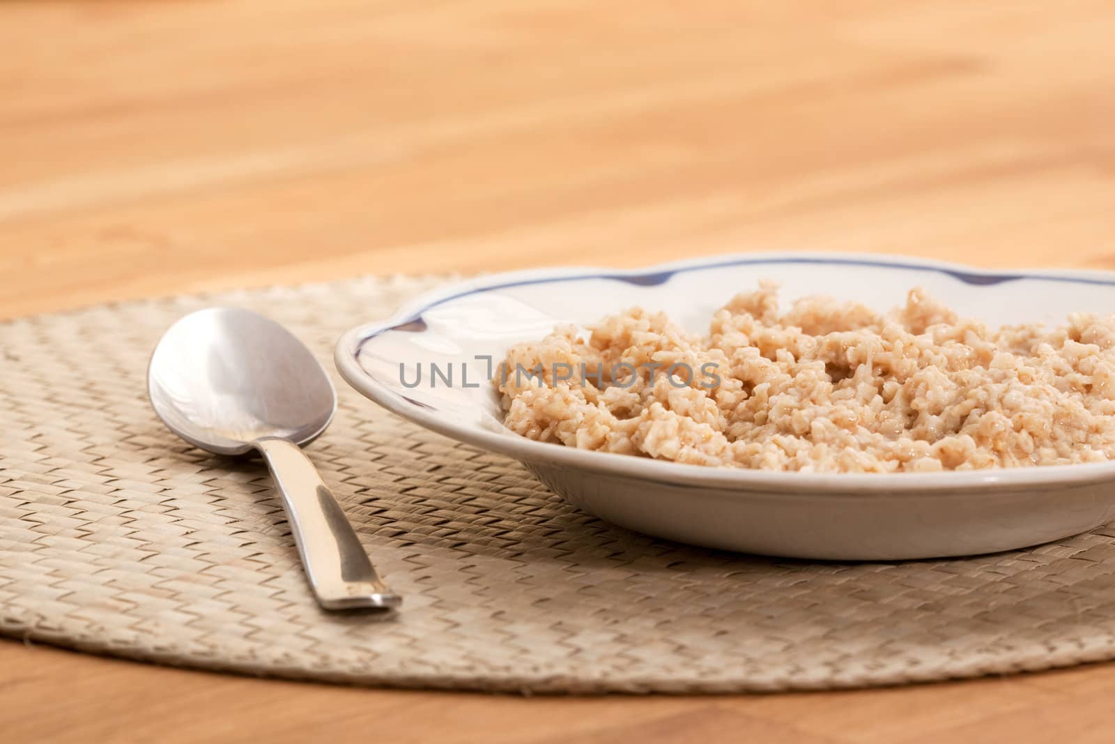 A bowl of porridge on a table with a spoon;