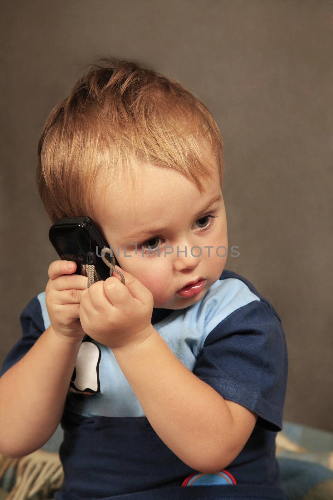 Photo of small boy with phone in studio