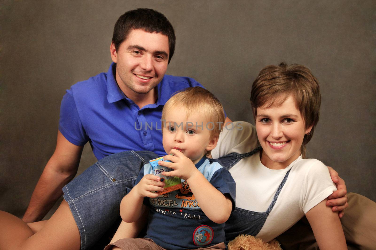 Happy young family with son in studio