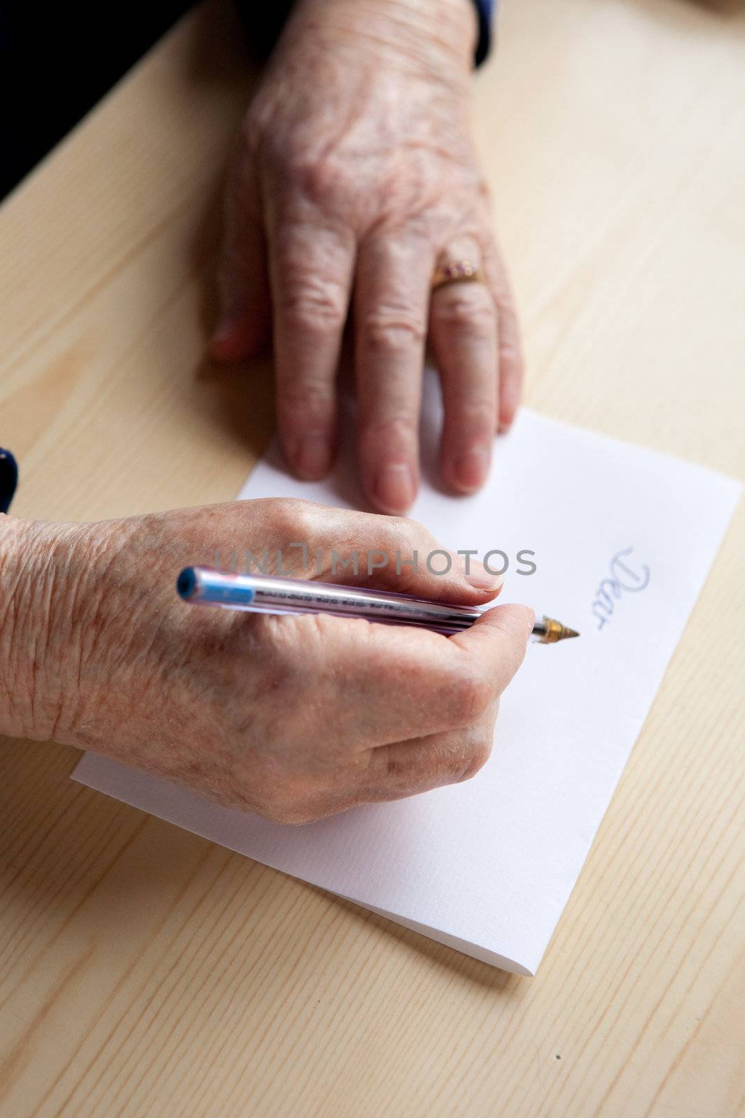 An old pair of hands writing a letter
