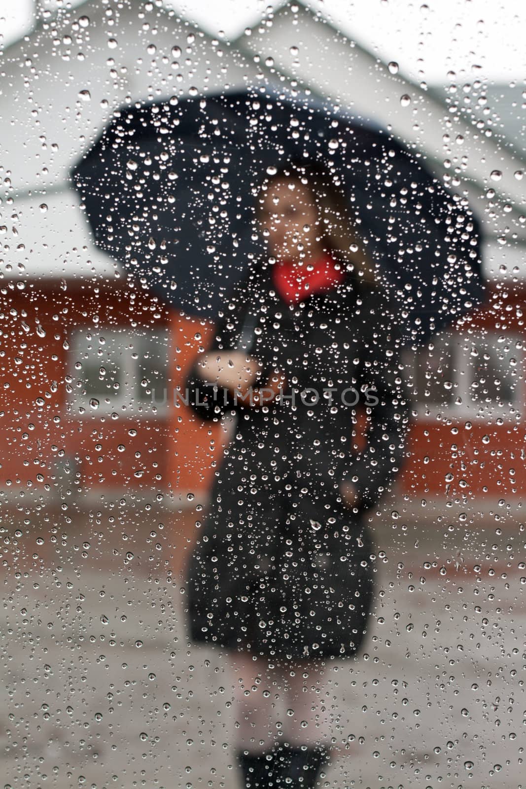 Beautiful girl with red scarf and umbrella for glass with drop of water