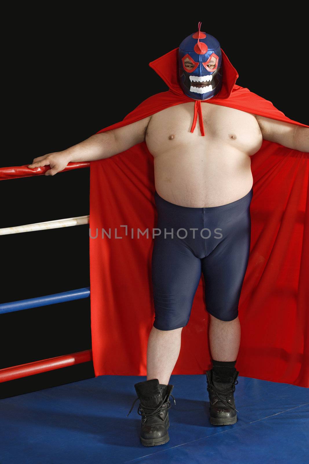 Photograph of a Mexican wrestler or Luchador standing in a wrestling ring.
