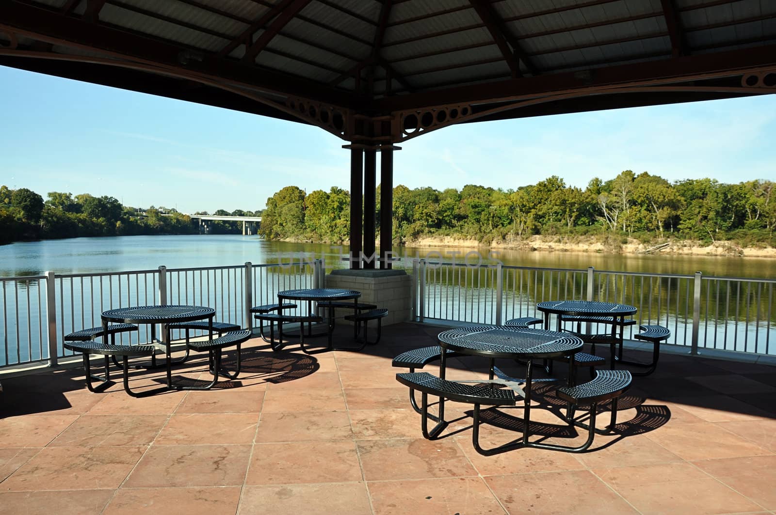 Picnic Tables on Pavilion Overlooking River by dehooks