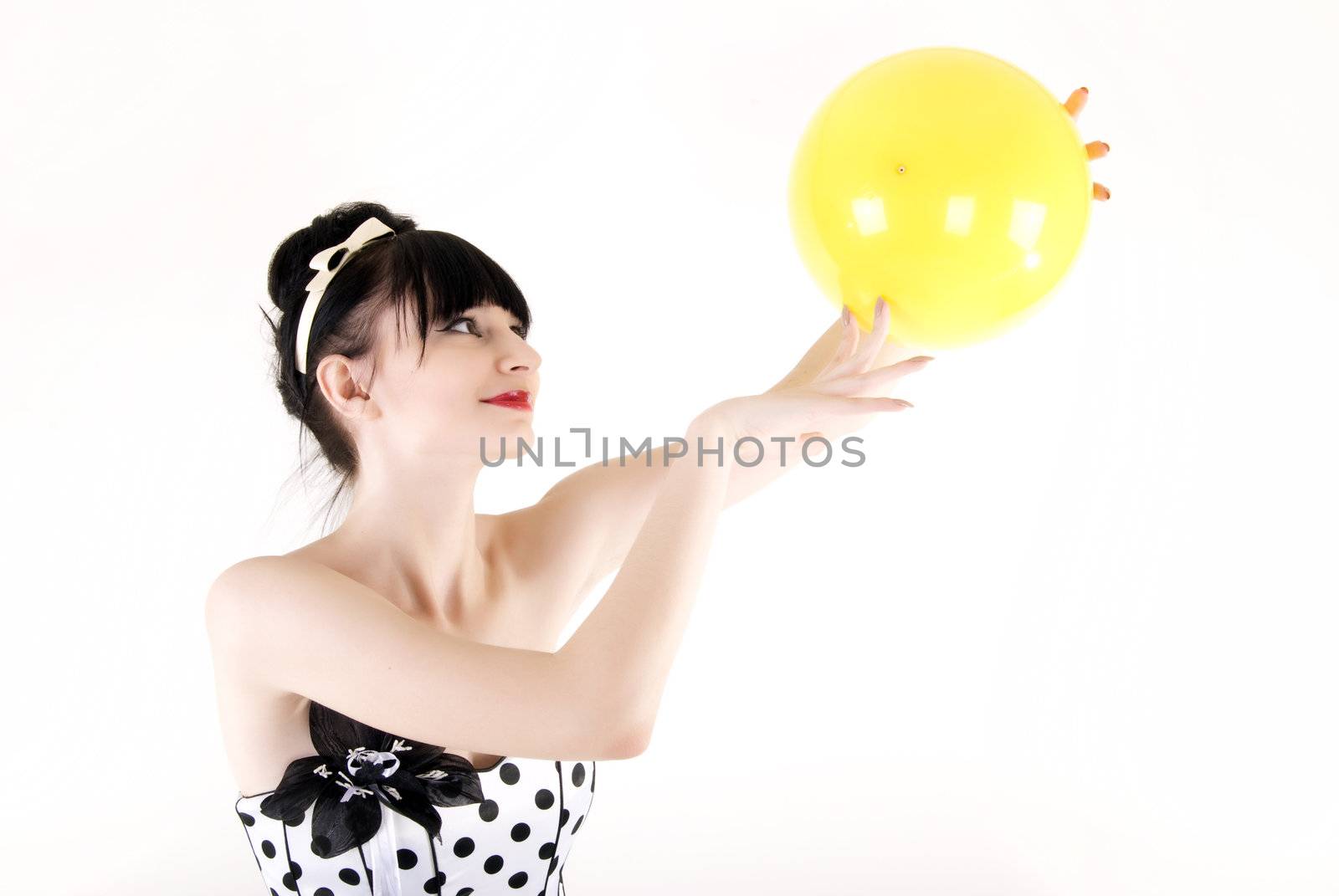 Portrait of a young beautiful brunette posing with yellow ball