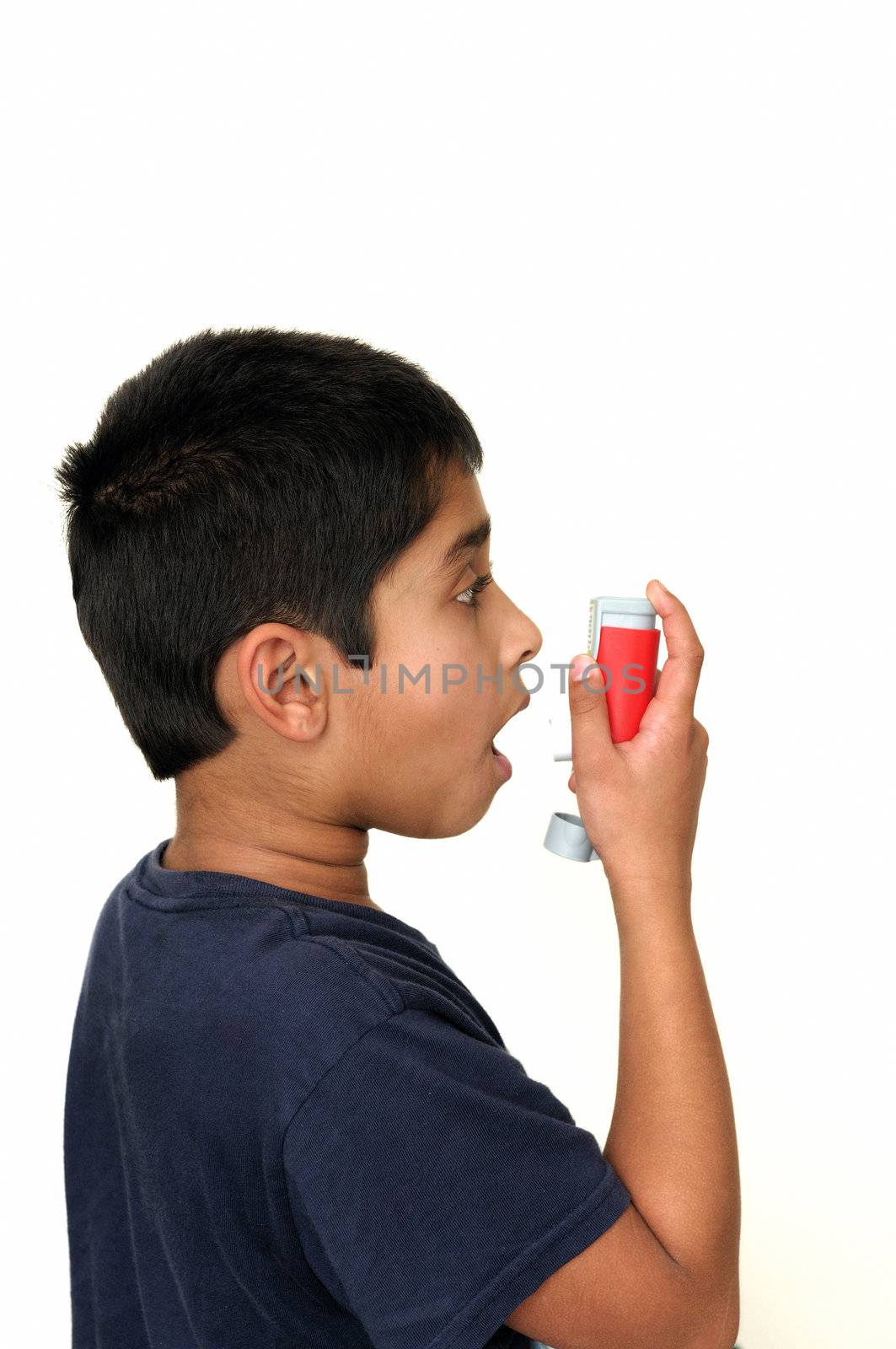 An handsome young Indian child using the inhaler