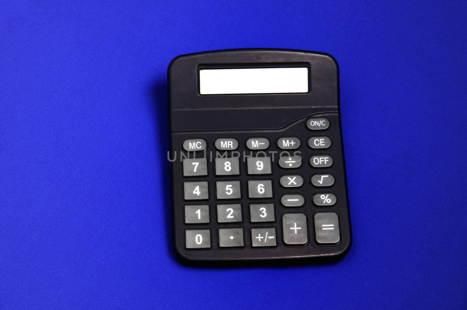 A desk calculator isolated on a blue back ground