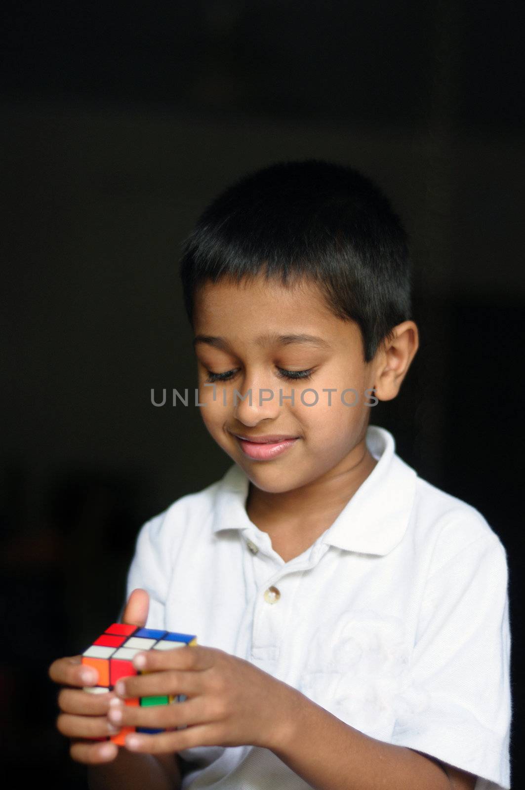 An handsome Indian kid solving a puzzle