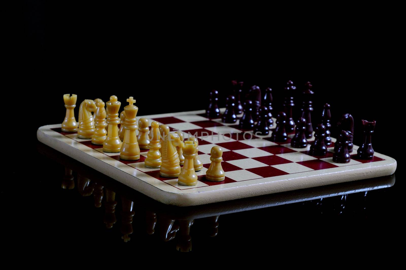 Chess board and coins isolated on a black background