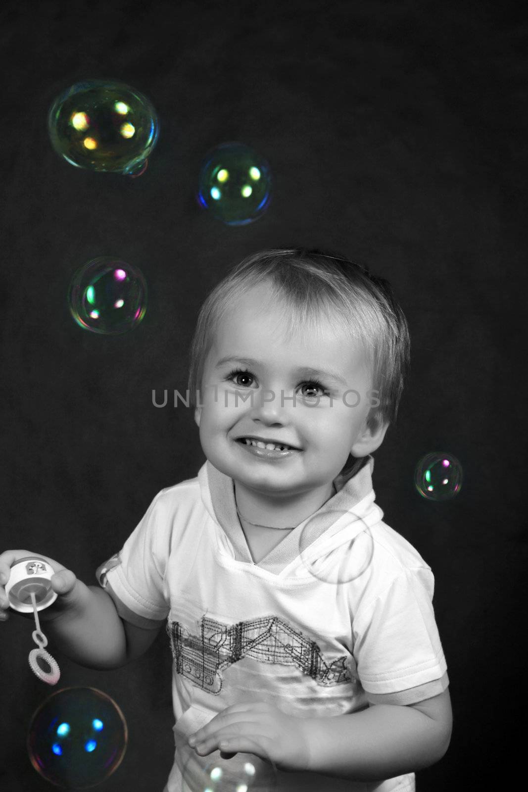 The small boy with soap bubbles in studio