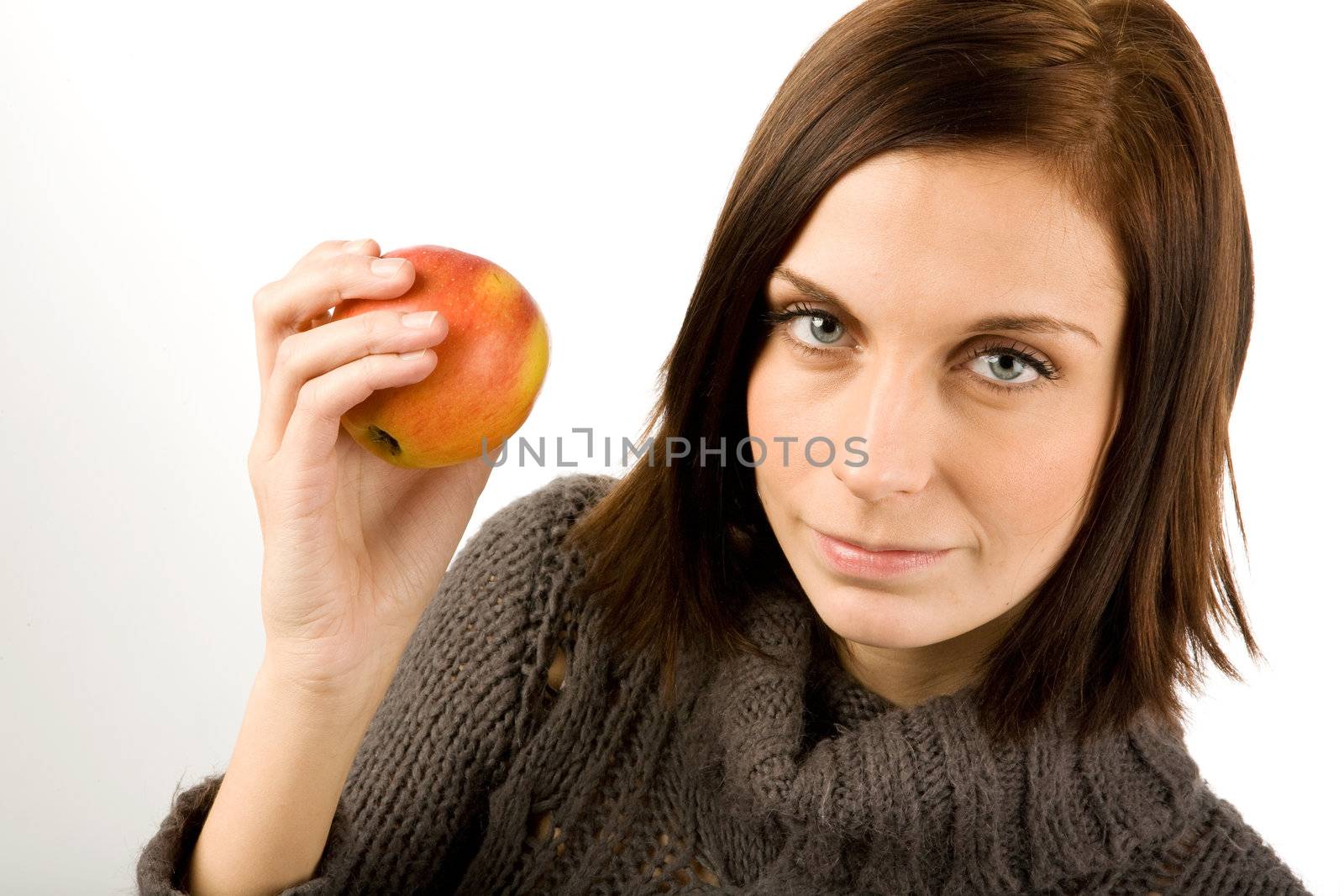 A woman holding an apple in a studio setting
