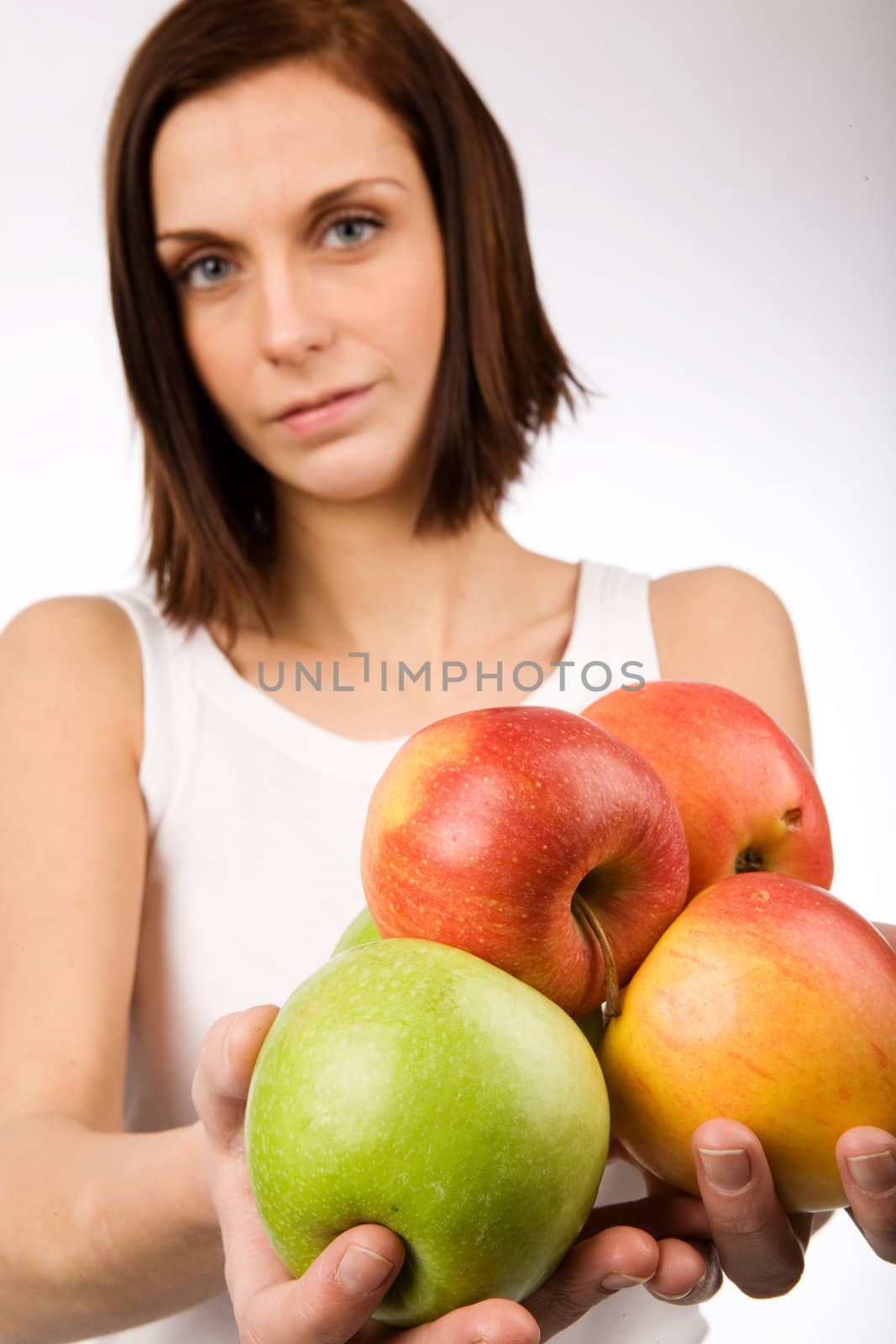 A young woman holding a bunch of apples