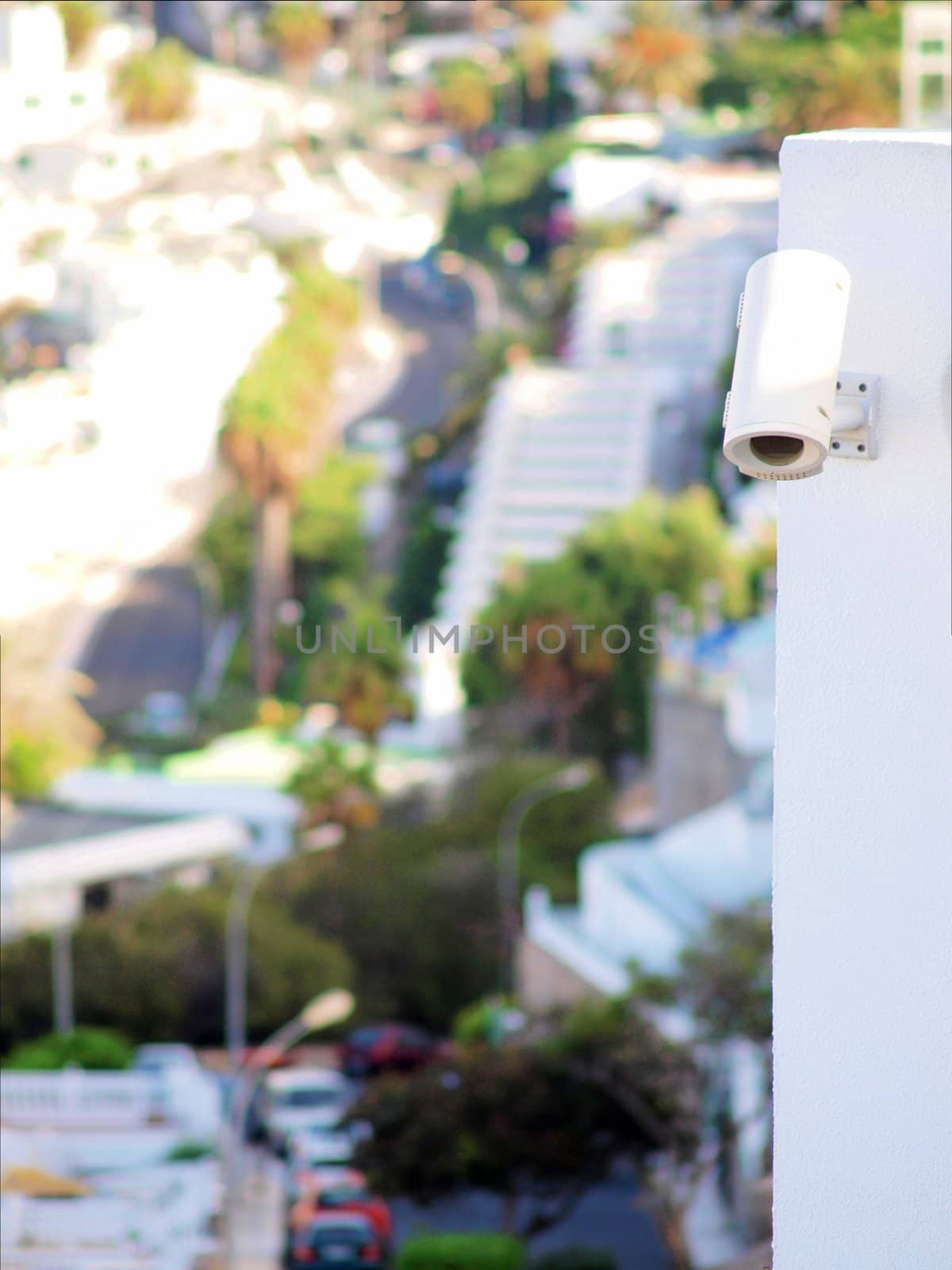 Security camera mounted on a wall above street