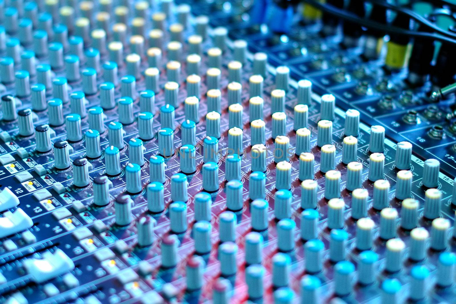 soundboard mixing desk under blue stage lighting