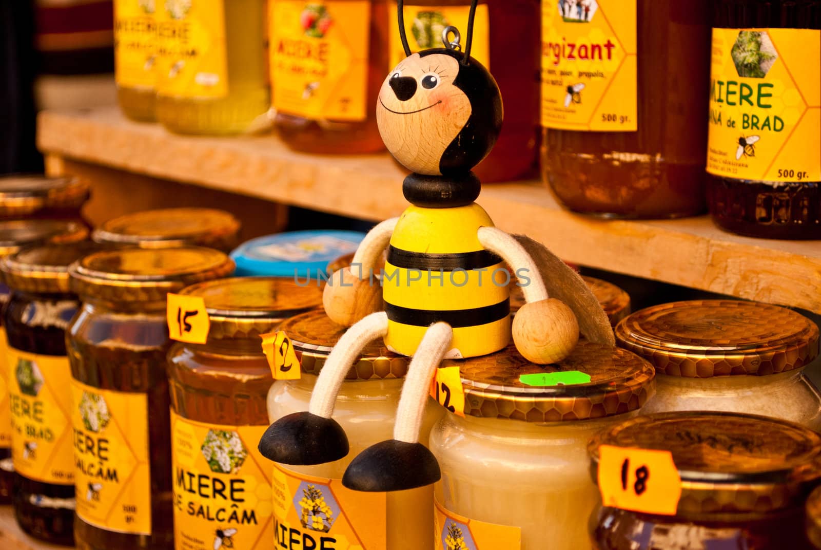 Black and yellow bee toy sitting on honey jar