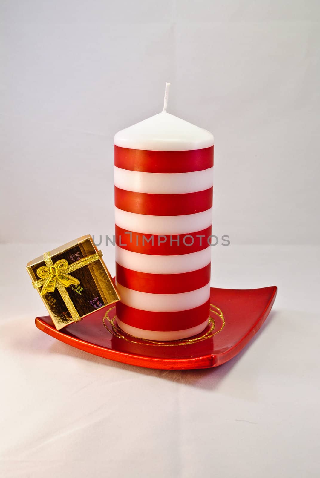 Red and white candle with golden gift box