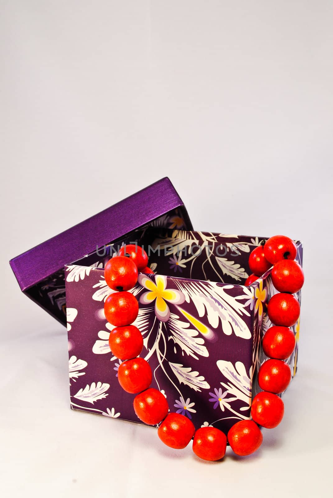 A purple gift box with red beads comming out