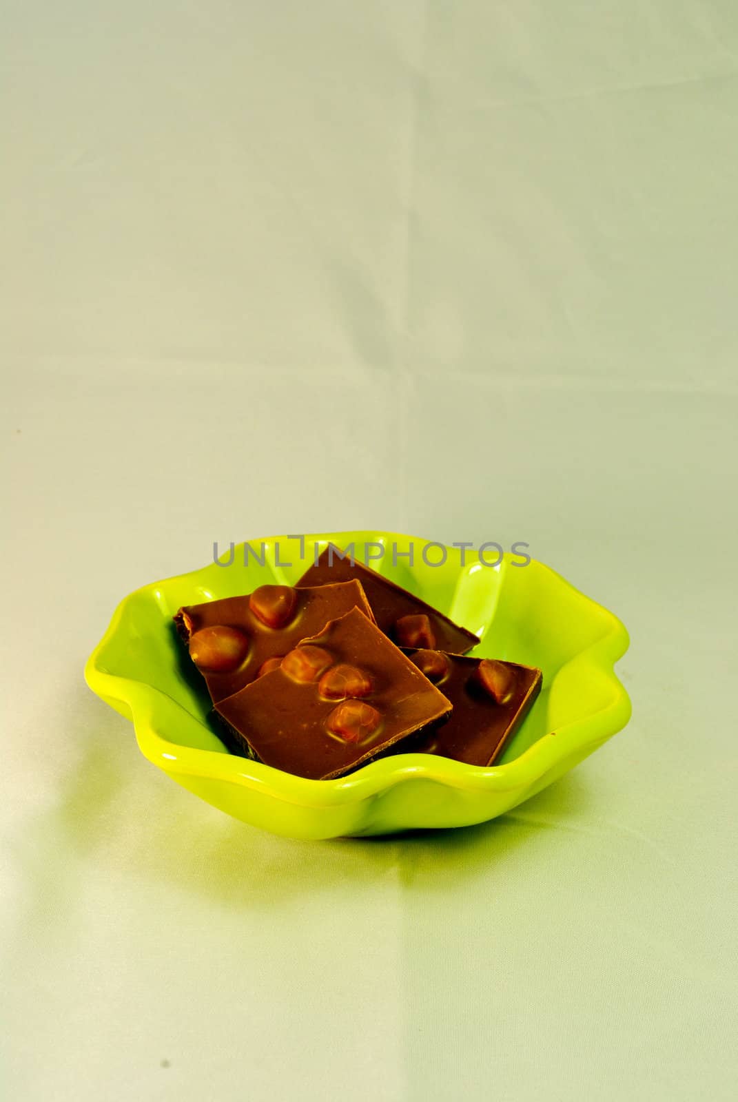 Dark hazelnuts chocolate on green plate